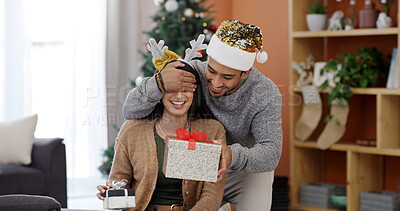 Buy stock photo Christmas, home and couple with gift, surprise and bonding together with happiness, wow and tradition. Xmas, apartment or man with woman, shocked and celebration with present or festive season