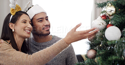 Buy stock photo Christmas tree, happy and couple with decoration in home for festive tradition, holiday season and celebration. December, love and man with woman with bauble for xmas aesthetic, vacation and bonding
