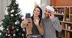 Christmas, video call and wave with couple in living room of home together for season greeting. Hand gesture, smile and streaming with happy people in apartment for festive celebration or tradition