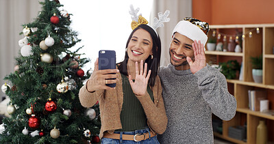 Buy stock photo Christmas, video call and wave with couple in living room of home together for season greeting. Hand gesture, smile and streaming with happy people in apartment for festive celebration or tradition