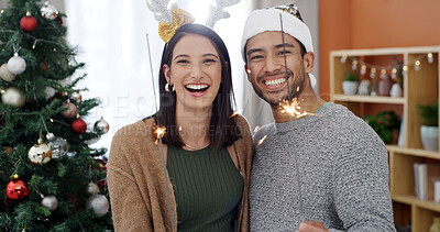 Buy stock photo Christmas, sparklers and couple with smile, portrait and bonding together with tradition. Xmas decoration, home or man with woman, excited or festive season with fireworks, holiday or laugh in lounge