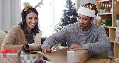 Buy stock photo Christmas, gift and wrapping paper with couple in living room of apartment for festive tradition. Celebration, present and teamwork with happy people in home for December or xmas holiday season