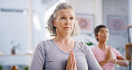 Elderly woman, prayer hands and stretching with yoga class for spiritual wellness or balance together. Senior people, yogi and personal trainer in pose for warm up, mindfulness or retirement exercise