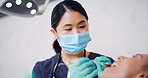 Dentist, patient and cleaning teeth in office with mask for oral hygiene, healthcare and wellness. Low angle, dental hygienist and woman with tools for tooth inspection, medical procedure and help.
