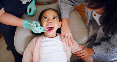 Buy stock photo Dentist, mother and girl with mouth inspection for oral hygiene, healthcare or wellness in clinic. Above, dental hygienist and child with mom in consultation with teeth exam, medical tool or support.