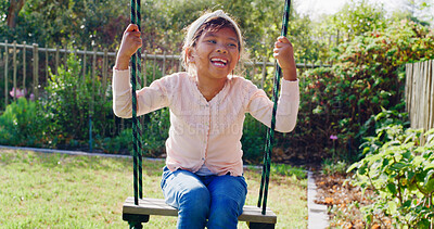 Buy stock photo Happy, girl and swing outdoor in backyard for fun activity, coordination and childhood development. Kid, playing and smile in garden with playground for holiday recreation, wellness or weekend break.