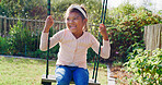 Kid, laugh and swing outdoor in backyard for fun activity, coordination and childhood development. Girl, playing and smile in garden with playground for holiday recreation, wellness or weekend break.