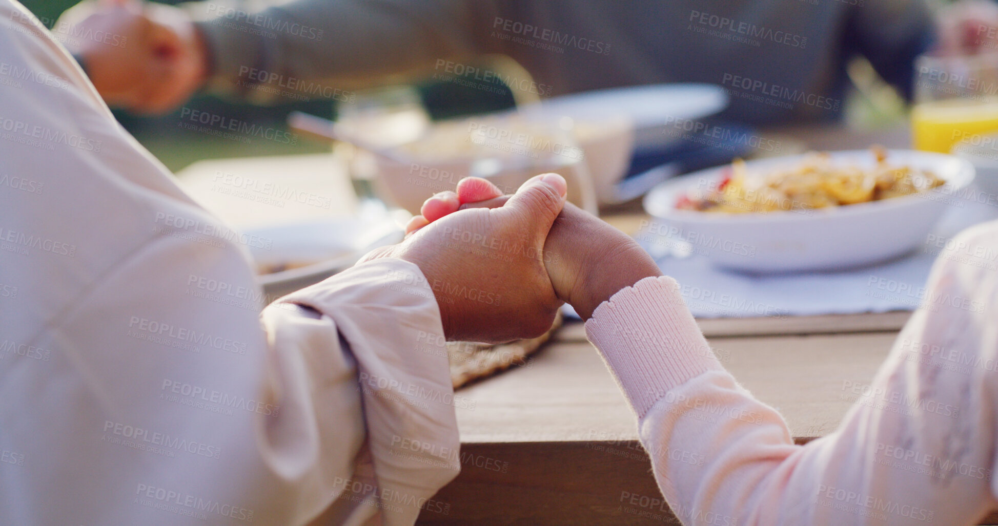 Buy stock photo Lunch, backyard and family holding hands by table to pray at celebration, gathering and festive dinner. Christmas, closeup and parents with child with faith, religion and grace for meal in holiday