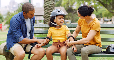 Buy stock photo Park, parents and child with helmet on bench for skating lesson, teaching safety and gear for protection. Family bonding, people and girl with elbow guard for outdoor, care and trust for learning