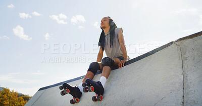 Buy stock photo Man, headphones or urban park with roller skates for fitness, aerobic exercise or outdoor hobby. Male person, hipster or wheel boots with music for parkour sport on concrete legde in city or town