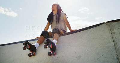 Buy stock photo Man, roller skates and relax at park with headphones, low angle or listen to music with space in city. African person, skater and break for streaming subscription, audio or rest on ramp in urban town