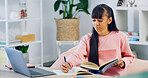 Woman, college student and writing notes in home for online course, review and prepare for exam. Person, books and laptop for elearning, scholarship or education with planning for university test