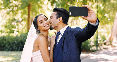 Buy stock photo Wedding, couple and selfie outdoor with kiss for special memory, love and post for marriage. Man, woman and picture of bride with groom at park for social media, romance and happy for celebration