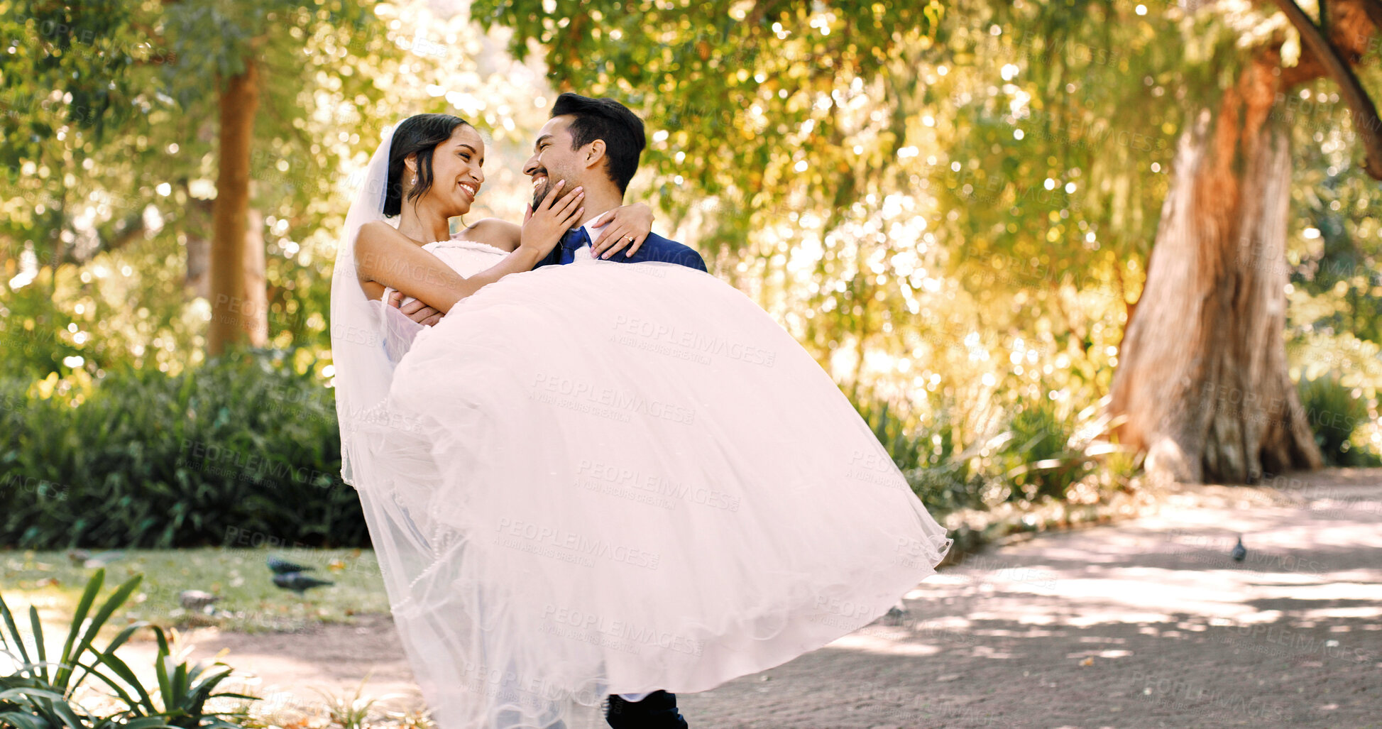 Buy stock photo Wedding, groom and carry bride at park for marriage celebration, relationship union and support. People, couple and lifting at ceremony in nature for love tradition, commitment and bonding together