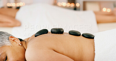 Buy stock photo Senior woman, relax or sleeping with hot rocks for massage, healing or physical therapy in spa. Elderly, female person or stones with candle light for stress relief or muscle tension in beauty resort
