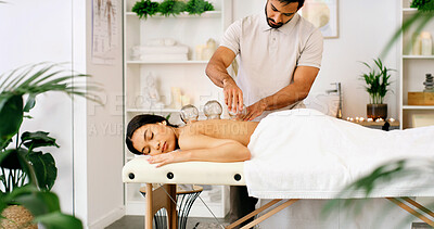 Buy stock photo Man, woman and cupping therapy on spa bed for blood flow benefits, detox and services at luxury resort. People, massage and glass with holistic wellness, circulation or healing inflammation at lodge