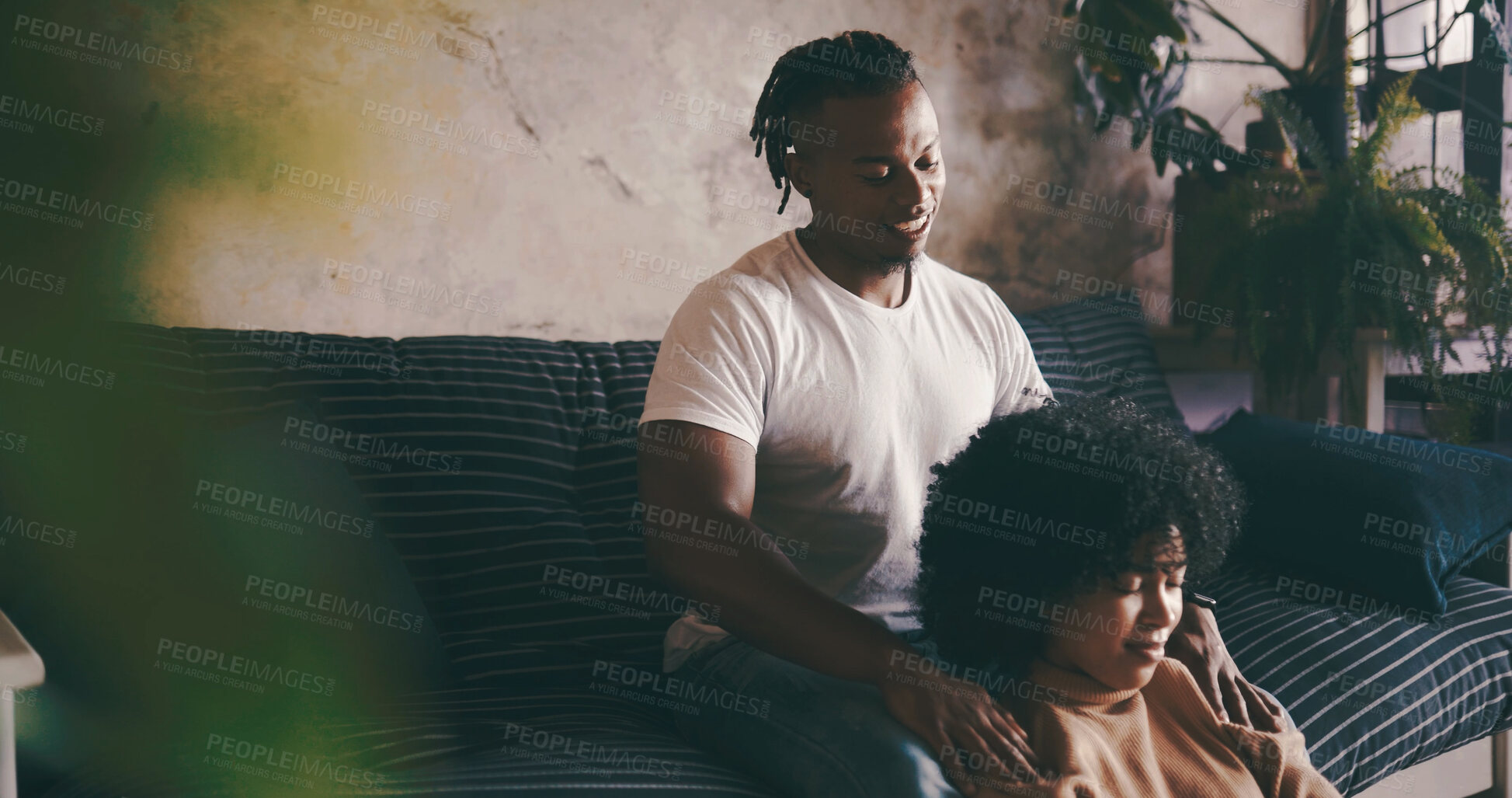 Buy stock photo Home, shoulder massage and couple with love, relax and bonding together with support. Happiness, black man or woman in lounge, smile or relationship with wellness, care and comfort with stress relief
