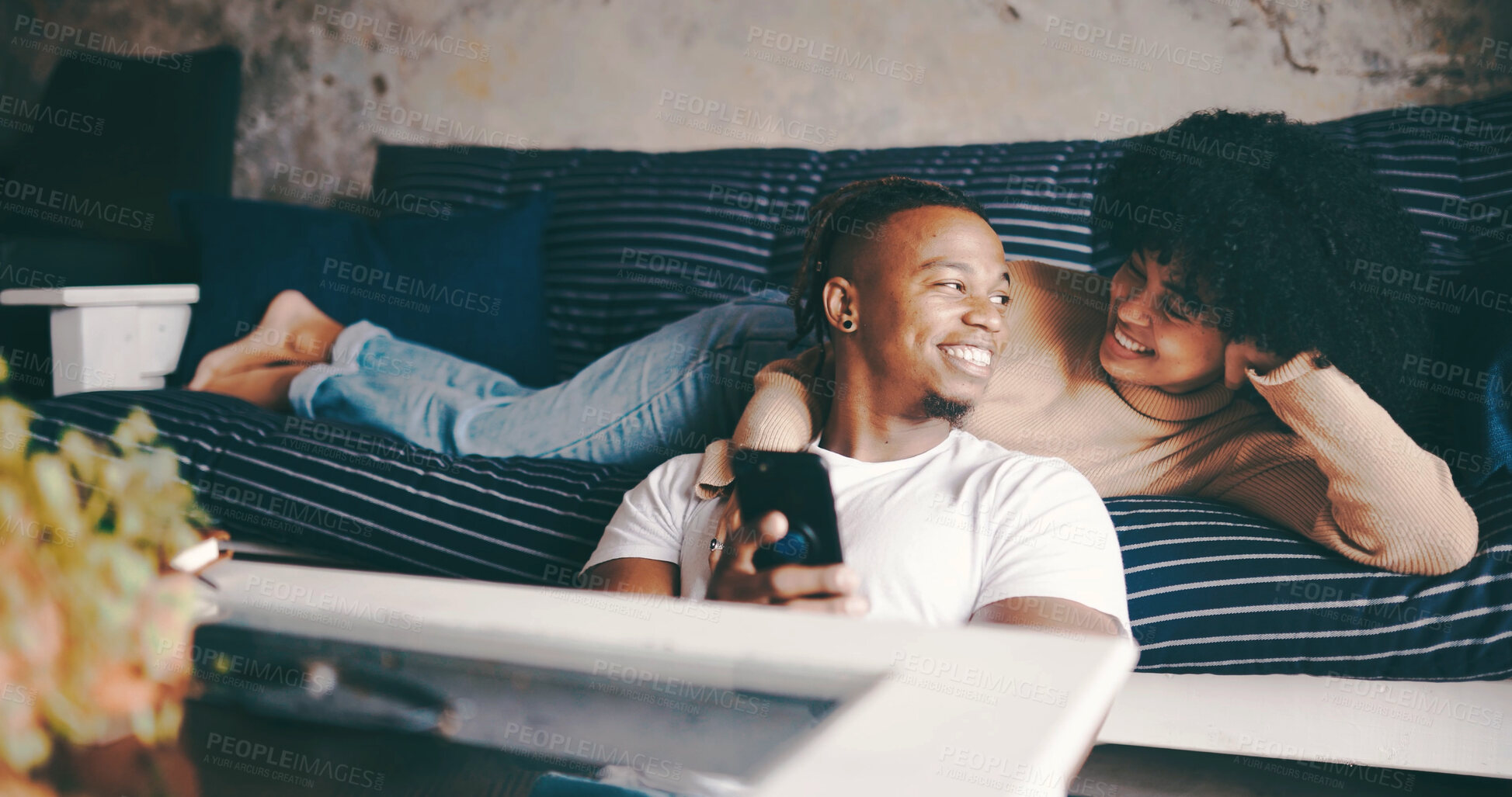 Buy stock photo Hug, couple and relax with phone on sofa for online videos, social media post or weekend break. Love, african people and happy with smartphone in home for streaming subscription and bonding together