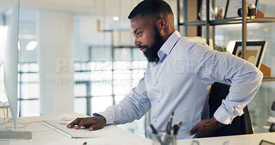 Buy stock photo Tired, man and computer in office with back pain from burnout, typing finance report and bad posture. Exhausted, black person and spinal strain in workplace with desktop, financial proposal or email.