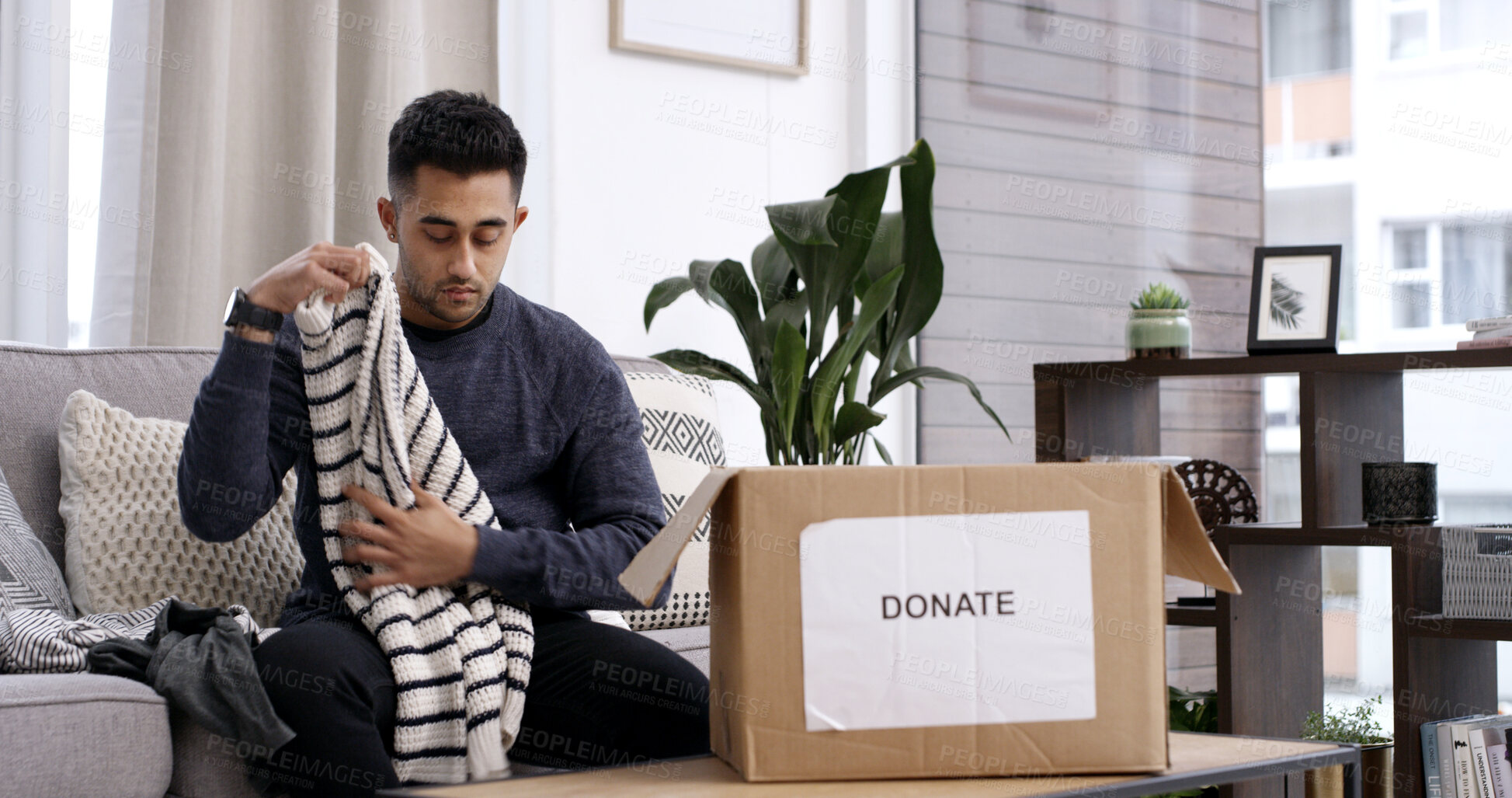 Buy stock photo Man, folding clothes and donation box in home for charity initiative, nonprofit and declutter closet. Person, package and apparel giveaway in house for NGO contribution, support and spring cleaning.