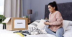 Woman, packing clothes and donation box in home for charity initiative, nonprofit and declutter closet. Person, package and apparel giveaway in cardboard for NGO support, parcel and spring cleaning.