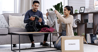 Buy stock photo Couple, fold clothes and donation box in living room for charity, nonprofit support or declutter home. Married people, apparel giveaway or parcel in house for NGO initiative, help or spring cleaning.