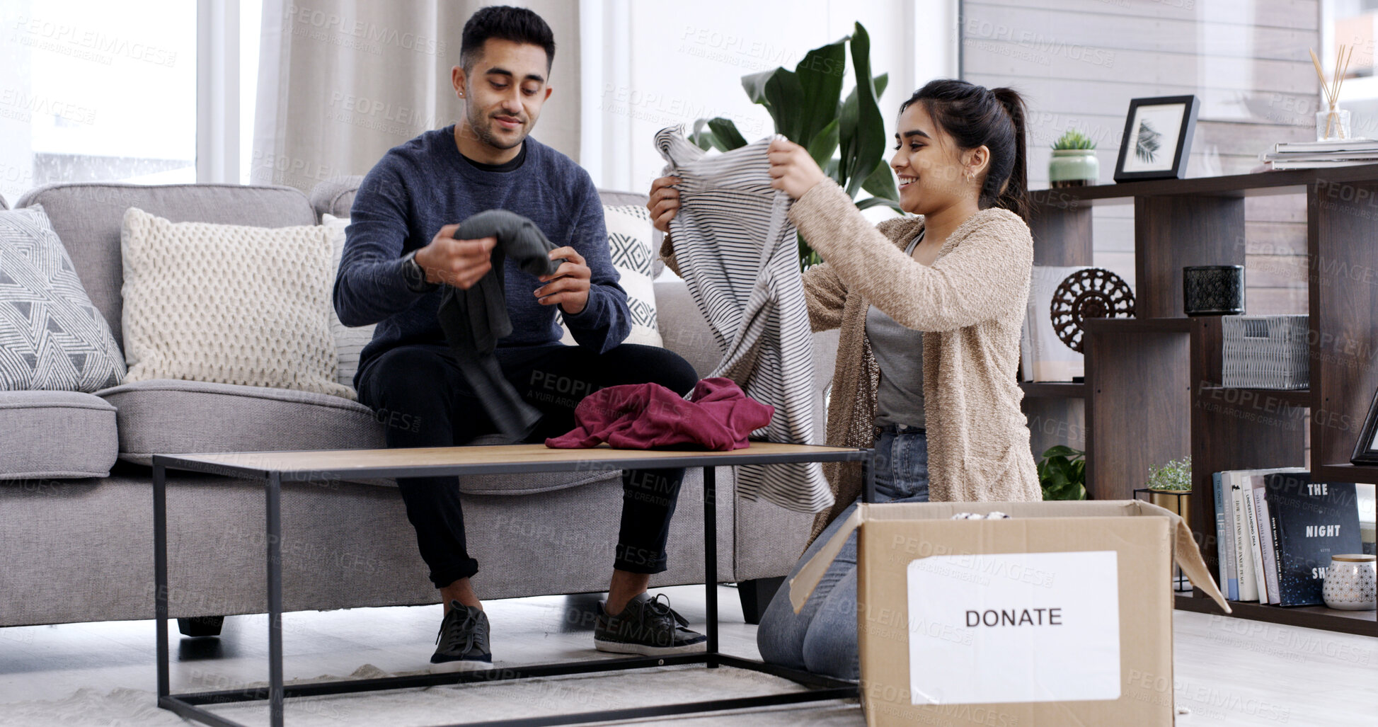 Buy stock photo Couple, fold clothes and donation box in living room for charity, nonprofit support or declutter home. Married people, apparel giveaway or parcel in house for NGO initiative, help or spring cleaning.