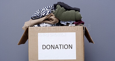 Buy stock photo Clothes, charity and donation box in studio for non profit, humanitarian aid or support package. Cardboard, garments and community care with outreach, ngo or help for philanthropy on gray background
