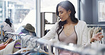 Woman, shopping and fashion with rack in store for decision, check quality and fabric texture. Female person, bag and choice for clothing, outfit option and retail selection for customer experience