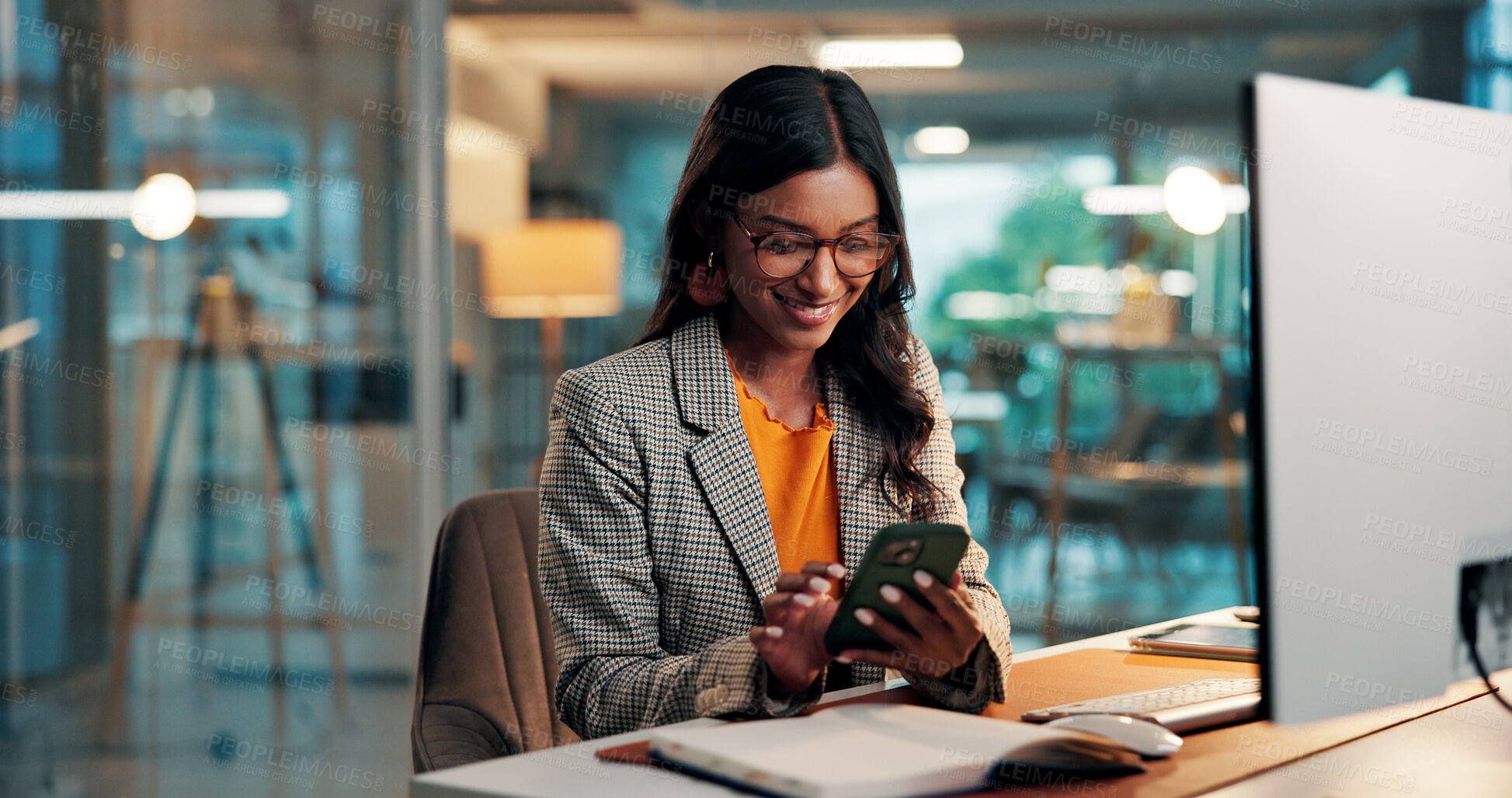 Buy stock photo Phone, message and woman with computer in office for creative project overtime with online article. Glasses, draft feedback and magazine editor with evening for review or publishing deadline on tech