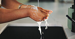 Person, hands and washing with water splash in kitchen for hygiene or disinfection in home. Closeup, rinse or cleaning germs with soap, tap or faucet in sink, basin or skin sanitization in house