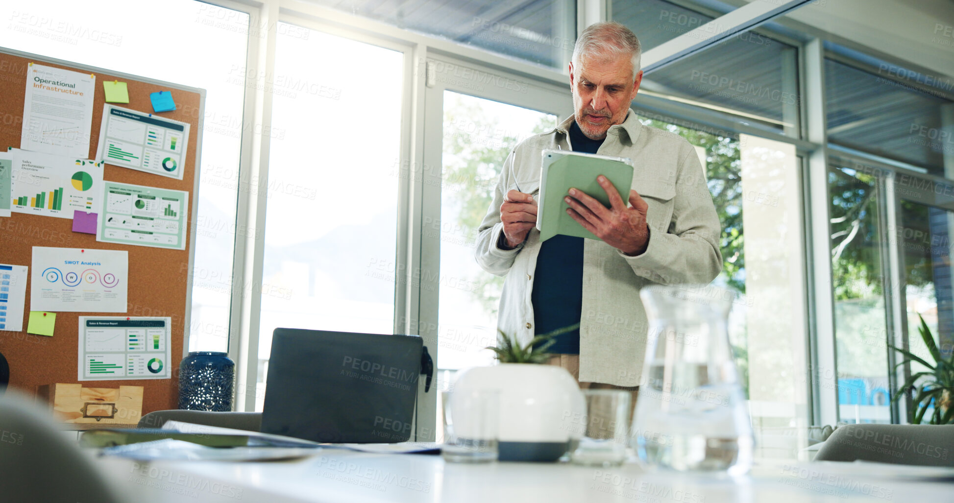 Buy stock photo Man, scroll or reading in office with tablet for sales performance stats, business management or planning. Mature person, research or browse in workplace with tech for SWOT analysis, charts or graphs