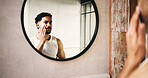 Man, skincare or moisturizer with mirror in bathroom for morning routine or cosmetics in home. Male person, reflection or cleaning with lotion, face cream or facial treatment for smooth skin in house