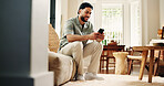 Man, typing and smile with phone on sofa for social media notification, online dating and virtual chat. Happy, person and scroll in home with tech for text message, browsing internet and mobile app.