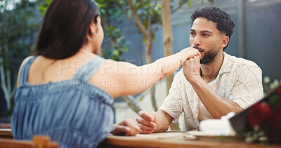 Buy stock photo Couple, holding hands and kiss on date at restaurant with bouquet, discussion and relationship milestone. Happy man, woman and connection with bonding, trust and flowers for anniversary at diner