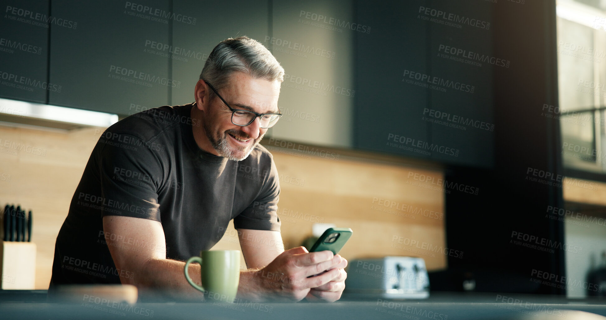 Buy stock photo Happy man, scroll and typing in kitchen with phone, social media notification and text message update. Mature person, smile and browsing with tech in home for news feed, online communication or chat.