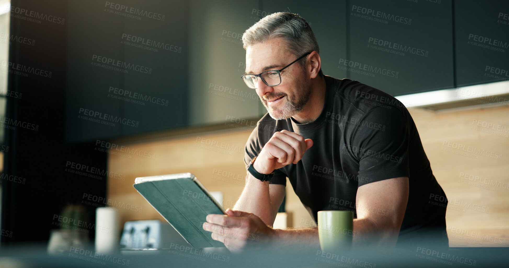 Buy stock photo Design, remote work and tablet with man in kitchen of home for planning, report or research. App, reading and small business startup with mature designer in apartment for review as freelance employee