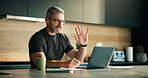 Laptop, remote work and video call with man in kitchen of home for planning, report or research. Computer, earphones and wave with mature freelancer in apartment for virtual meeting or webinar