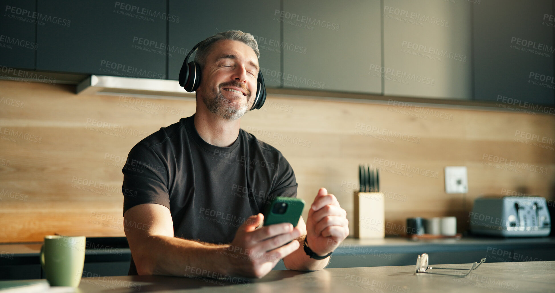 Buy stock photo Headphones, streaming or man in home with dance, song connectivity or listening to music playlist. Rhythm, mature or male person in kitchen with tech, feeling beat or radio subscription on audio app.