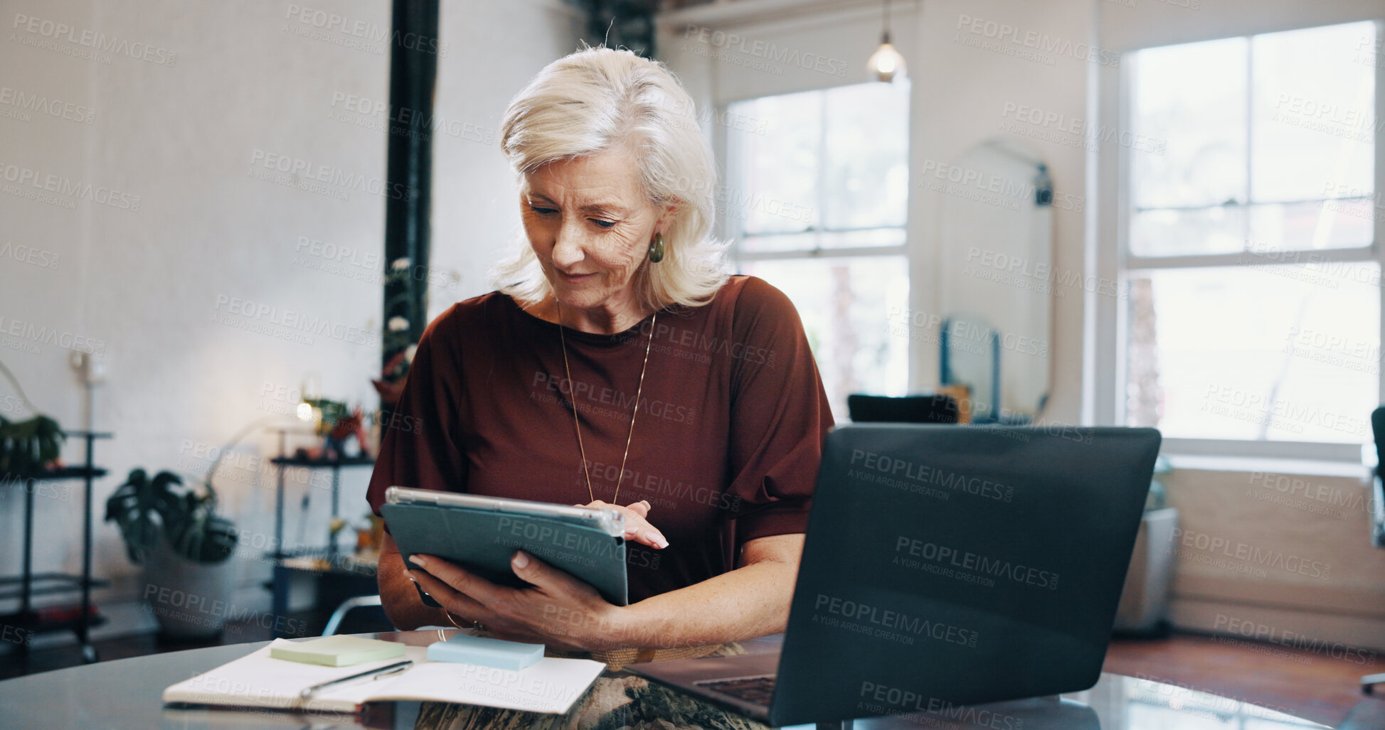 Buy stock photo Reading, research and tablet with woman at desk in small business startup for feedback or review. App, laptop and notebook with mature employee in office for online planning, report or strategy