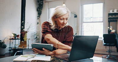 Buy stock photo Laptop, research and tablet with woman at desk in small business startup for planning or review. App, computer and reading information with mature employee in office for management or online report