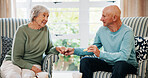 Holding hands, senior couple and eating breakfast in morning with love, care and bonding in home. Elderly man, woman and enjoy cookies in living room with support, connection and happy in retirement