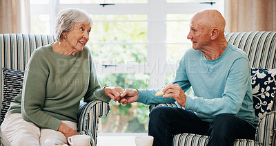Buy stock photo Holding hands, senior couple and eating breakfast in morning with love, care and bonding in home. Elderly man, woman and enjoy cookies in living room with support, connection and happy in retirement