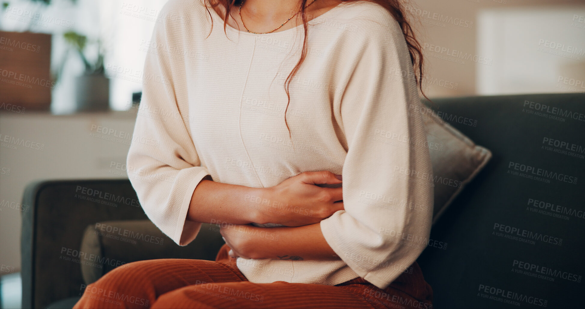 Buy stock photo Hands, woman and discomfort of stomach pain at house of menstruation, constipation and cramps. Female person, sore and uncomfortable from appendicitis, gastritis symptoms and chronic endometriosis