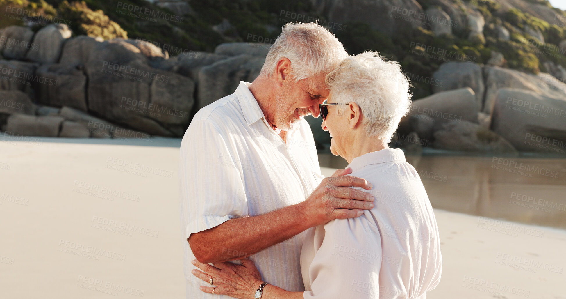 Buy stock photo Senior couple, hug and beach with love for retirement holiday, weekend or outdoor getaway together. Elderly, man and woman with smile or embrace on ocean coast for summer romance or date in nature