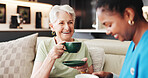 Coffee, healthcare or laughing with nurse and old woman on sofa in living room of home together. Caffeine, funny or medical with happy caregiver and senior patient drinking beverage in apartment