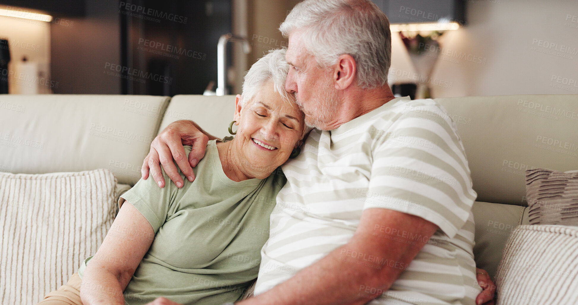 Buy stock photo Love, smile and forehead kiss with old couple on sofa for bonding retirement and connection. Support, happiness and marriage partner with elderly man and woman in home for commitment and trust