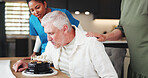 Senior man, caregiver and birthday with cake for anniversary in retirement home together. Elderly, male person and woman with nurse or blowing candles for love, romance or celebration in house