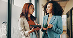 Tablet, coffee and women in office with meeting for communication, schedule and contact or planning. Team, conversation and journalist with tech, creative people and morning drink in agency hallway