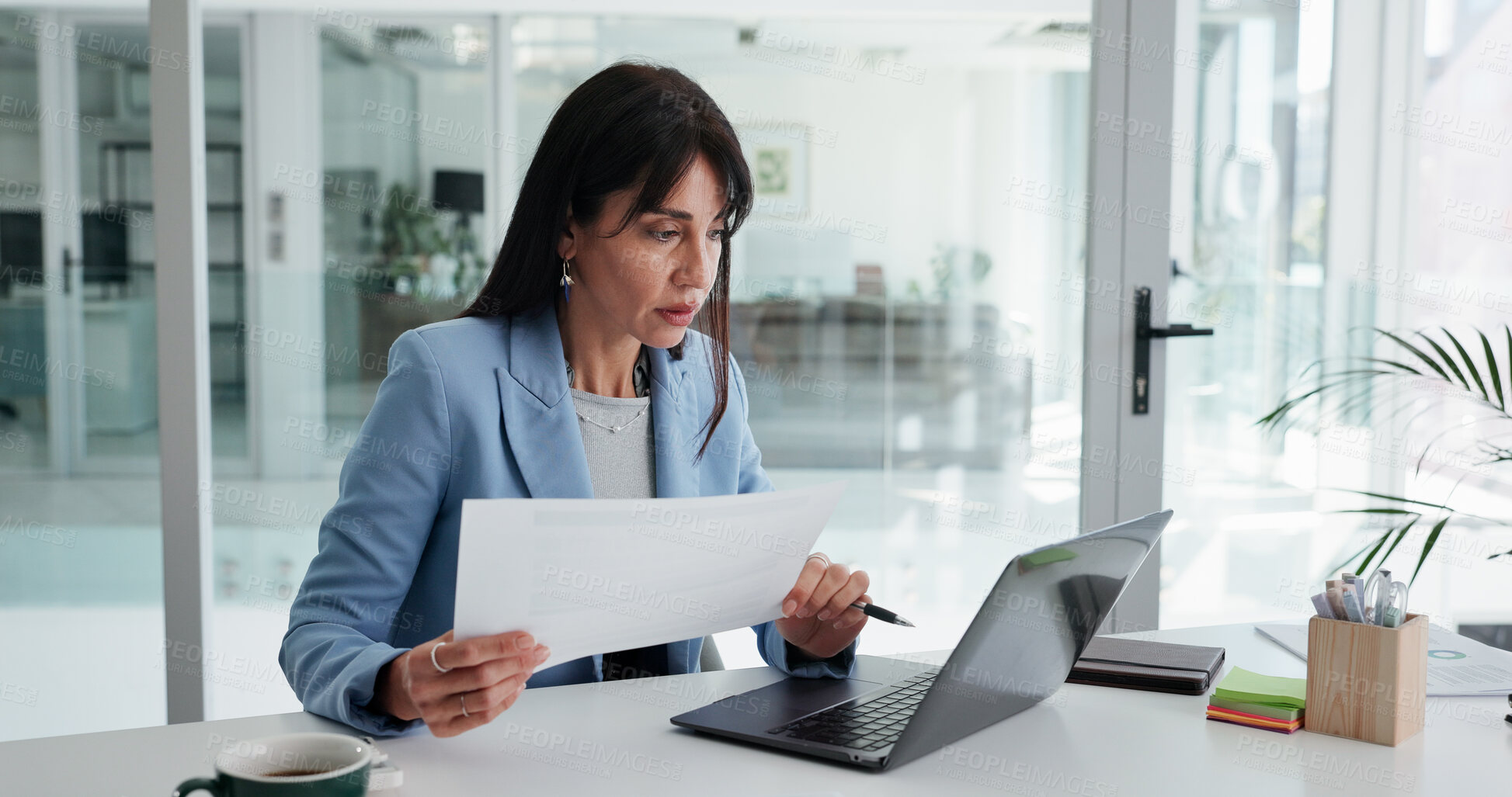 Buy stock photo Woman, reading and paperwork in office with laptop for financial statement, budget proposal and report. Mature person, computer and document with review for finance management, planning and research.